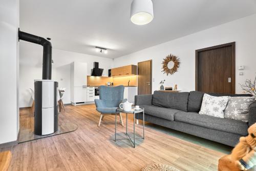 a living room with a gray couch and a table at Apartmány BD Boží Dar by Mountain ways in Boží Dar