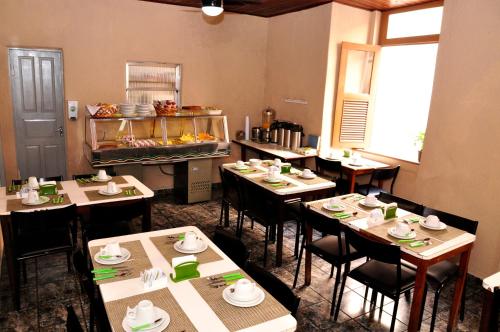 a dining room with tables and chairs in a restaurant at Hotel Plaza Riazor in Rio de Janeiro