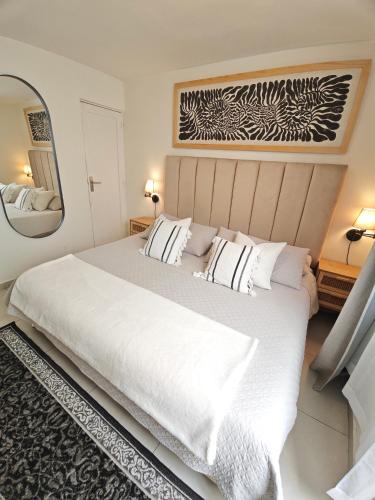 a bedroom with a large white bed and a mirror at Comfy Habitación en Puebla! in San Baltasar