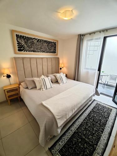 a bedroom with a large bed and a balcony at Comfy Habitación en Puebla! in San Baltasar