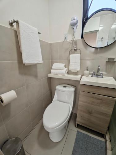 a bathroom with a toilet and a sink and a mirror at Comfy Habitación en Puebla! in San Baltasar