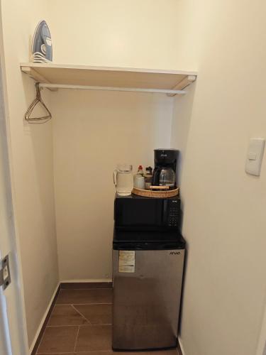 a small refrigerator in a hallway with a shelf at Comfy Habitación en Puebla! in San Baltasar