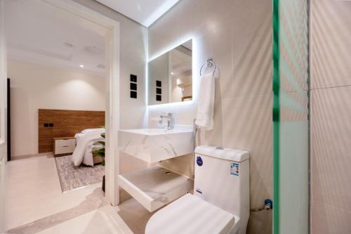 a bathroom with a sink and a toilet and a mirror at Rewaq Resident رواق ريزدنت in Medina