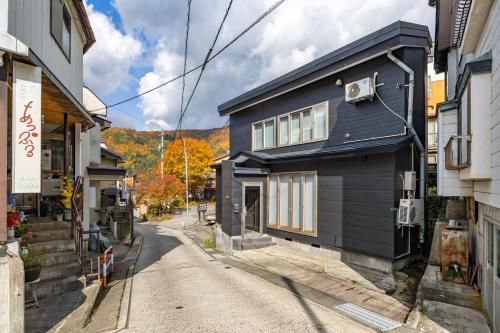 a blue house on the side of a street at Kalik House in Nozawa Onsen
