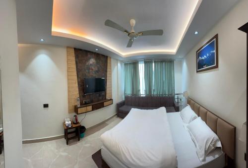 a bedroom with a bed and a flat screen tv at Hotel Buransh in Haldwāni