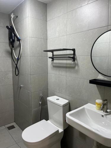 a bathroom with a toilet and a sink and a mirror at De' Moysis Homestay in Batu Caves