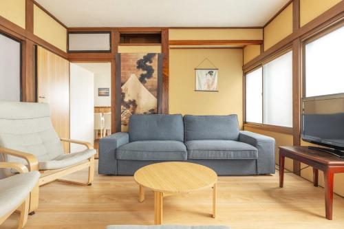 a living room with a blue couch and a table at James House in Nozawa Onsen
