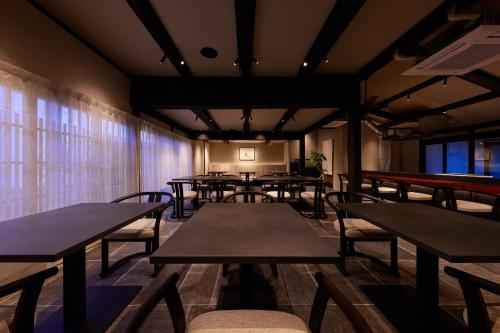 a row of tables and chairs in a room at Tomonoura Shiomachi Hotel in Fukuyama