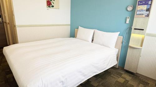 a bed in a small room with a white mattress at Toyoko Inn Hiroshima-eki Shinkansen-guchi No.2 in Hiroshima