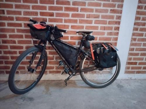 a bike is parked against a brick wall at Une Jai Place เรือนอุ่นใจ in Phimai