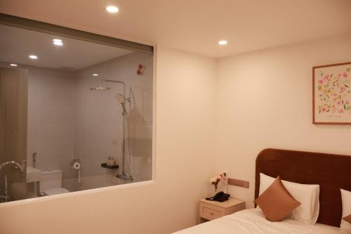 a bedroom with a bathroom with a shower and a bed at Veluna Hotel Mang Den in Kon Tum (2)
