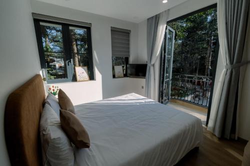 a bedroom with a bed and a large window at Veluna Hotel Mang Den in Kon Tum (2)