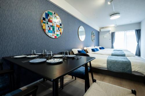 a hotel room with a bed and a table with plates on it at Zee Haven nagasakiekimae - ZEE HAVEN長崎駅前 in Nagasaki