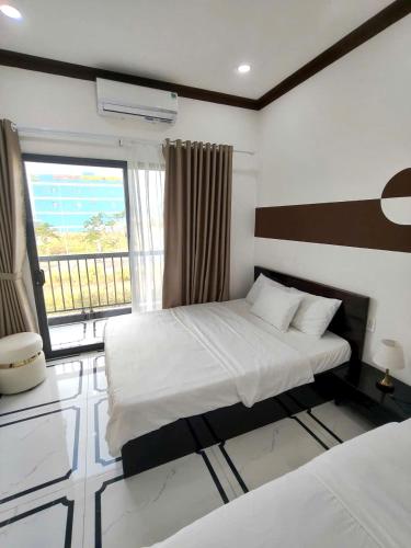 a bedroom with two beds and a window at Villa RonRoy Hà Tiên in Hà Tiên