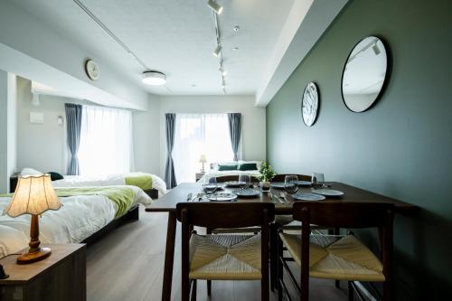 a room with a dining table and a bedroom at Zee Haven nagasakiekimae - ZEE HAVEN長崎駅前 in Nagasaki
