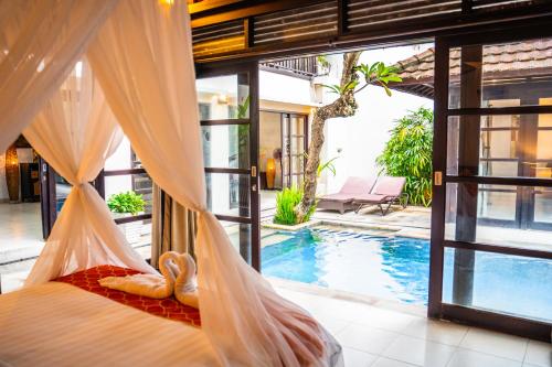 a bedroom with a hammock and a swimming pool at Villa Kubu Pratiwi - Villa 2 in Canggu