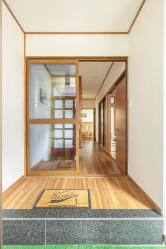 a hallway with glass doors and a mat on the floor at James House in Nozawa Onsen