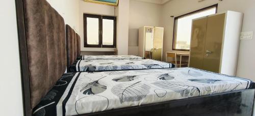 two beds are lined up in a room at Homely Space PG in Noida