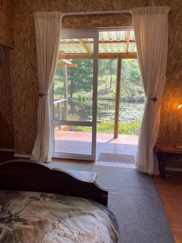 a bedroom with a bed and a sliding glass door at Olivias Cottage in Knysna