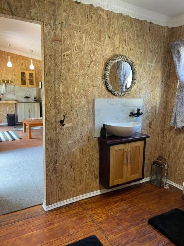 a bathroom with a sink and a mirror on a wall at Olivias Cottage in Knysna