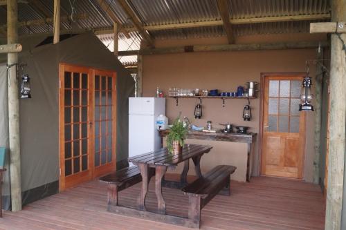 a kitchen with a table and a refrigerator in a room at Pure Nature Familodge in Paterson