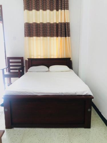 a small bed in a room with a curtain at Lumora Resort in Nochchiyagama