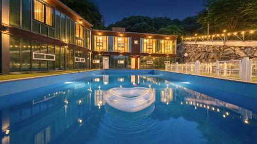 a house with a swimming pool at night at Gapyeong Santa Maria Dog-friendly Privat in Gapyeong