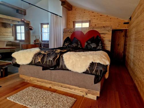 a bedroom with a bed in a log cabin at Faschingalm Loft in Lienz