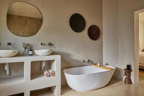 a bathroom with a large white tub and two sinks at Kokon Boutique Guesthouse in Somerset West