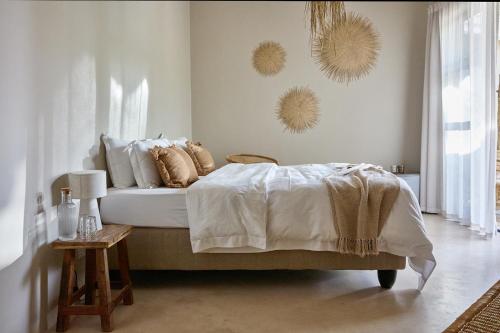 a bedroom with a bed and a table and mirrors at Kokon Boutique Guesthouse in Somerset West