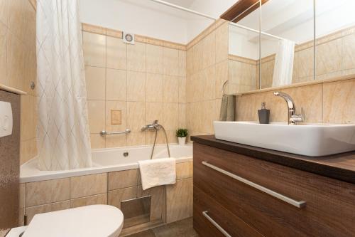 a bathroom with a sink and a tub and a toilet at Pansion Tina in Šilo