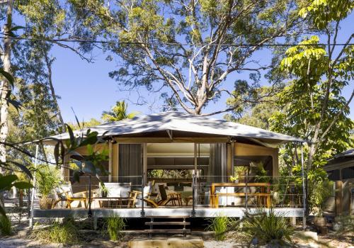 a house in the bush with an umbrella at BIG4 Noosa North Shore in Noosa North Shore