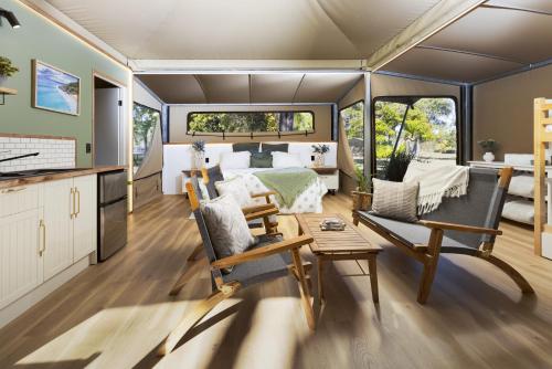 a caravan bedroom with a bed and a living room at BIG4 Noosa North Shore in Noosa North Shore