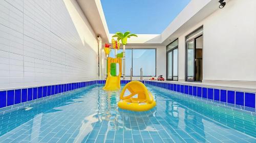 a swimming pool with a yellow slide in the middle at Goseong Belossi Ayajin Kids Poolvilla in Goseong