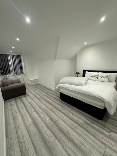 a white bedroom with a large bed and a chair at Whitford living 2 in Jarrow
