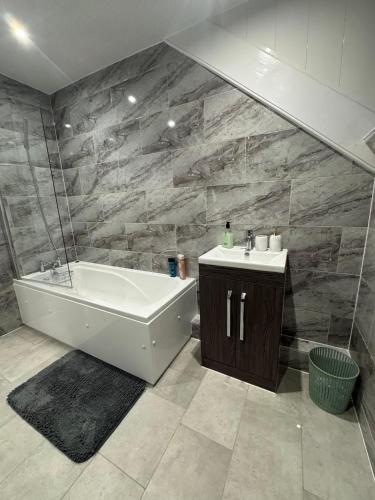 a bathroom with a bath tub and a sink at Whitford living 2 in Jarrow