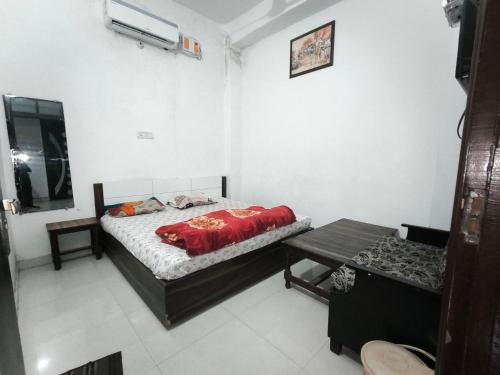 a bedroom with a bed and a table in it at Arjun House Hotel- Guest House in Pathānkot