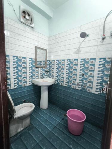 a blue and white bathroom with a sink and a toilet at Arjun House Hotel- Guest House in Pathānkot