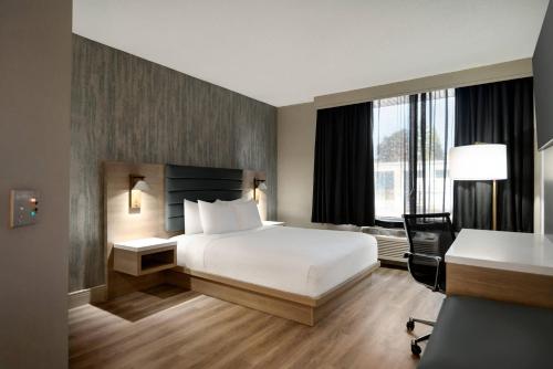 a hotel room with a bed and a desk at Radisson Hotel Montreal Airport in Ville Saint Laurent