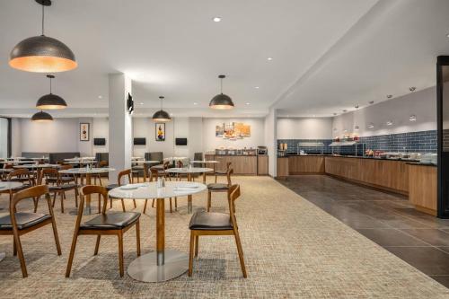 a restaurant with tables and chairs and a cafeteria at Radisson Hotel Montreal Airport in Saint-Laurent