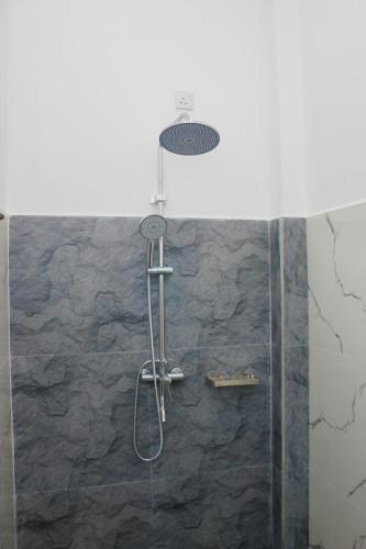 a shower in a bathroom with a stone wall at Anula Villa in Ahangama