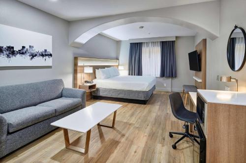 a hotel room with a bed and a couch at Radisson Hotel El Paso Airport in El Paso