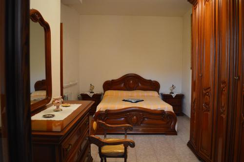 1 dormitorio con cama, tocador y espejo en Casa Vacanze Cuore del Pollino, en Viggianello