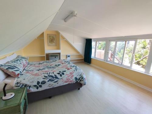 a bedroom with a bed and a large window at Billy Bay Cottage in Margate