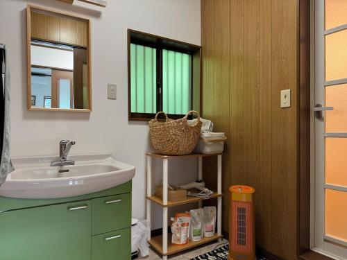 a bathroom with a sink and a mirror at 海輪邸 in Shima