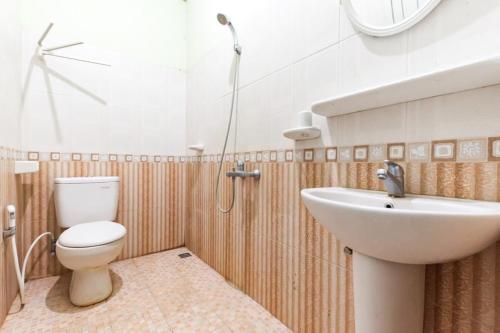 a bathroom with a toilet and a sink at Urbanview Hotel Bartu Moh Toha Bandung by RedDoorz in Bandung