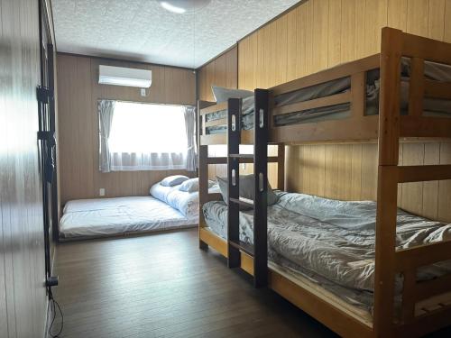 a room with two bunk beds and a window at 海輪邸 in Shima