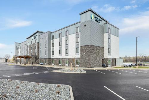 a large building with a parking lot in front of it at WoodSpring Suites Medford near I-5 in Medford