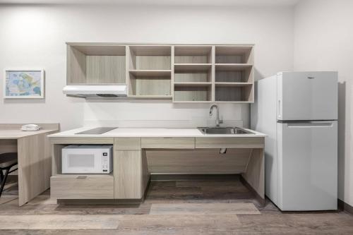 a kitchen with a sink and a refrigerator at WoodSpring Suites Medford near I-5 in Medford