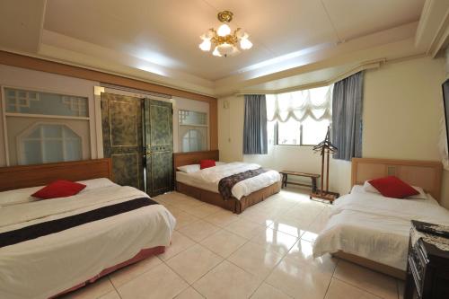 a hotel room with two beds and a window at Yun Siang Ju Homestay in Jiaoxi